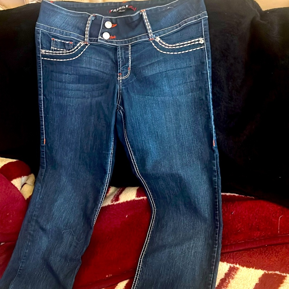 Women hip hugger jeans in white thread stitching, 2button, zipper, pockets.